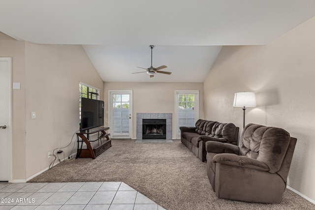 living room featuring light colored carpet, a tile fireplace, and lofted ceiling