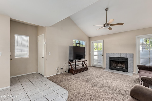 living room with a tiled fireplace, a healthy amount of sunlight, ceiling fan, and light tile patterned flooring