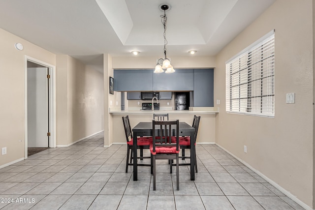 tiled dining area featuring a chandelier