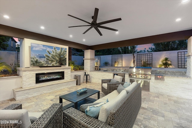 patio terrace at dusk featuring area for grilling and ceiling fan