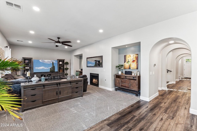 living room with dark hardwood / wood-style flooring and ceiling fan