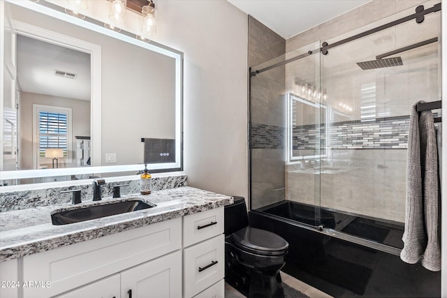 full bathroom featuring bath / shower combo with glass door, vanity, and toilet