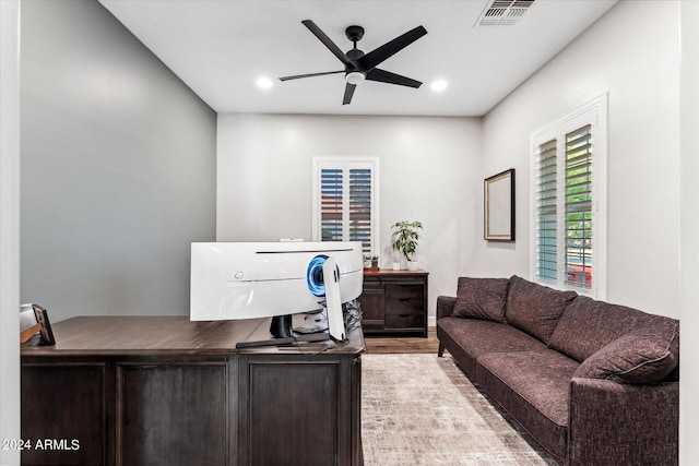 home office with light wood-type flooring and ceiling fan