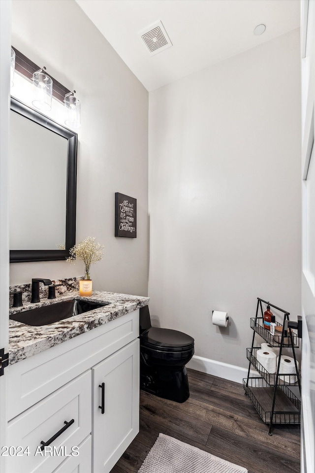 bathroom with hardwood / wood-style flooring, vanity, and toilet