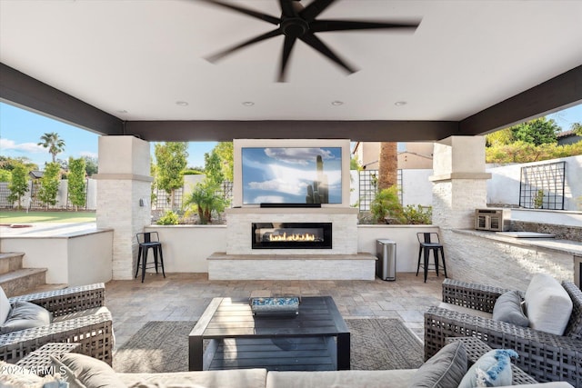 view of patio featuring an outdoor living space with a fireplace, an outdoor bar, and ceiling fan