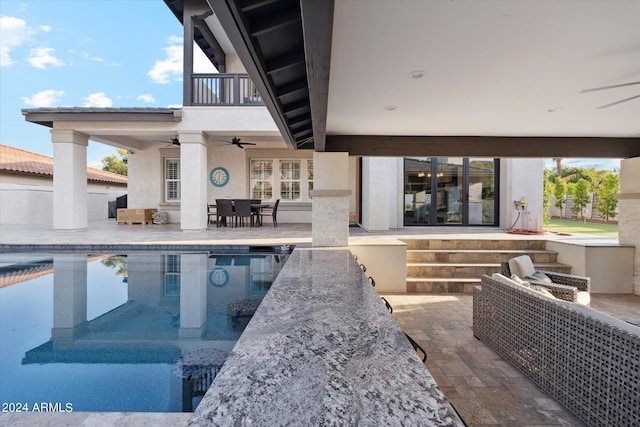 view of swimming pool with ceiling fan and a patio