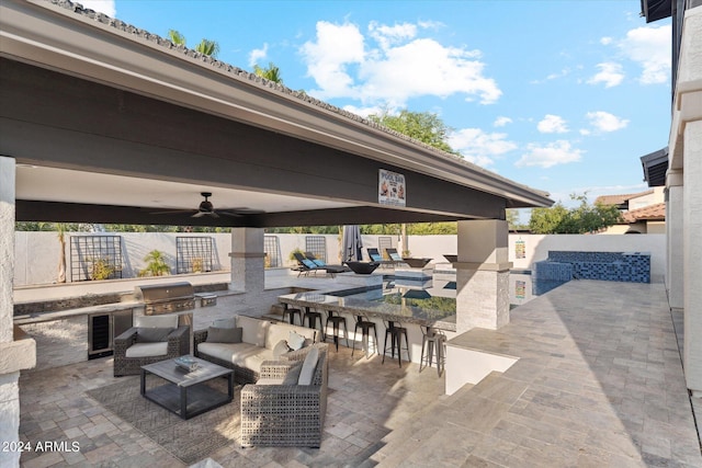 view of patio / terrace featuring ceiling fan, outdoor lounge area, a grill, and exterior kitchen