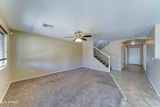 10524 W Pima St, Tolleson, AZ 85353 - unfurnished living room with arched walkways, a ceiling fan, stairway, and light carpet