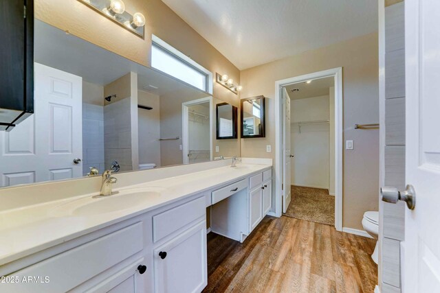 10524 W Pima St, Tolleson, AZ 85353 - bathroom featuring double vanity, wood finished floors, tiled shower, and a spacious closet