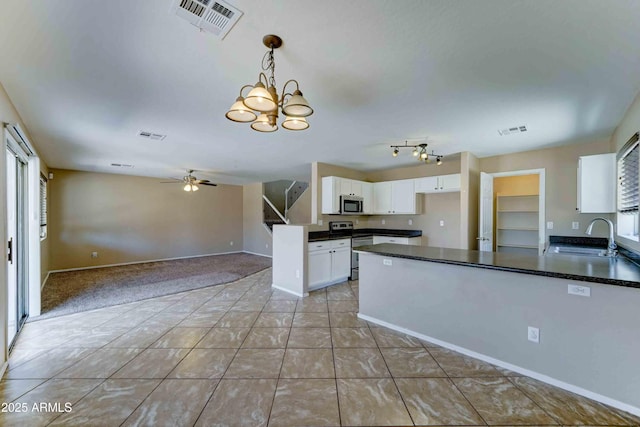 10524 W Pima St, Tolleson, AZ 85353 - kitchen featuring stainless steel appliances, dark countertops, white cabinets, a peninsula, and a ceiling fan