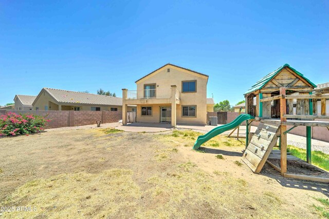 10524 W Pima St, Tolleson, AZ 85353 - back of house featuring a balcony, a fenced backyard, a playground, stucco siding, and a patio