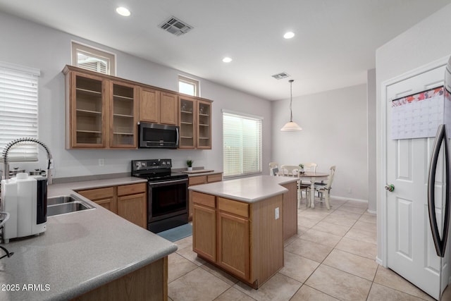 kitchen with sink, plenty of natural light, black range with electric cooktop, a kitchen island, and pendant lighting