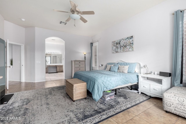 bedroom featuring ceiling fan, ensuite bath, and tile patterned flooring