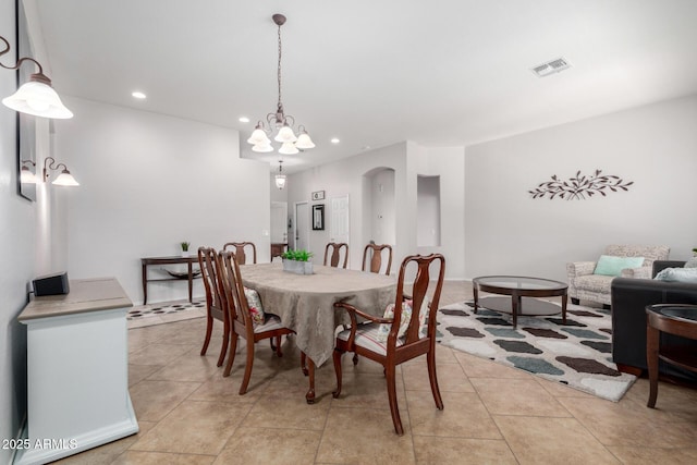 tiled dining room featuring a chandelier