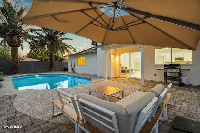 6201 E Waltann Ln, Scottsdale, AZ 85254 - pool at dusk featuring a grill, a patio, a fenced backyard, and an outdoor living space