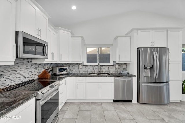 6201 E Waltann Ln, Scottsdale, AZ 85254 - kitchen with appliances with stainless steel finishes, tasteful backsplash, white cabinetry, dark stone counters, and vaulted ceiling