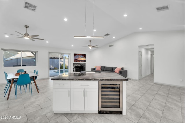 6201 E Waltann Ln, Scottsdale, AZ 85254 - kitchen with wine cooler, ceiling fan, open floor plan, vaulted ceiling, and white cabinetry