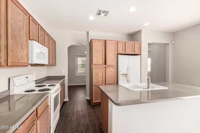 kitchen with arched walkways, recessed lighting, white appliances, a sink, and visible vents