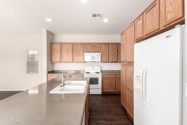 kitchen featuring dark wood-style floors, recessed lighting, visible vents, a sink, and white appliances