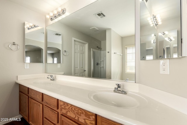 bathroom with visible vents, a walk in shower, and a sink