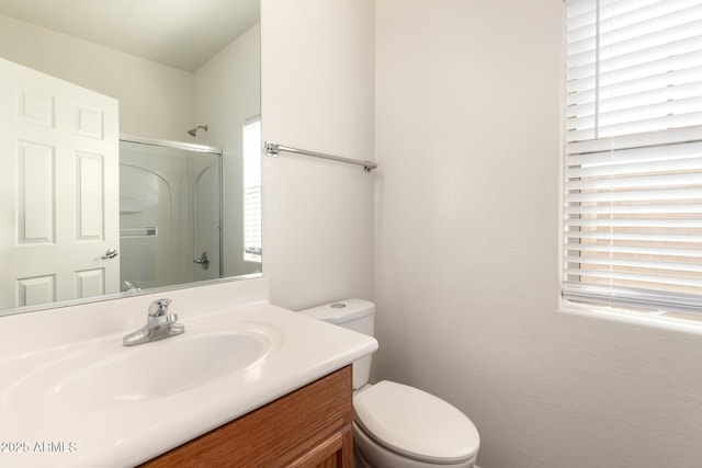 bathroom featuring toilet, a shower, and vanity