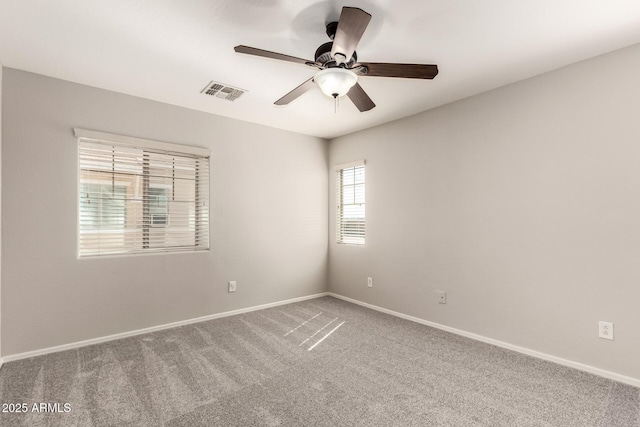 spare room featuring baseboards, visible vents, ceiling fan, and carpet flooring