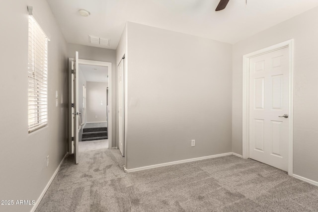 interior space featuring baseboards, visible vents, and carpet flooring