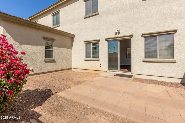 doorway to property with a patio area and stucco siding