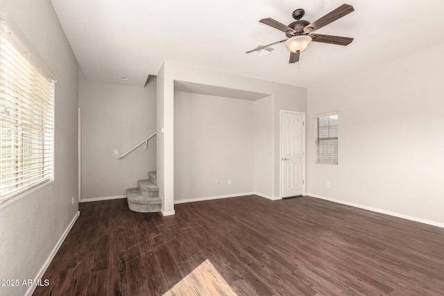 unfurnished living room featuring dark wood-style flooring, visible vents, stairway, and baseboards