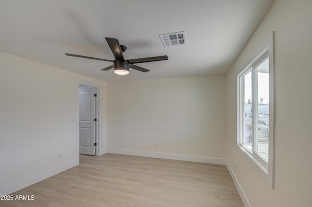 spare room featuring light wood-type flooring, a healthy amount of sunlight, and ceiling fan