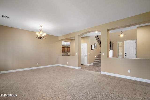2614 E Carob Dr, Gilbert, AZ 85298 - unfurnished room with light carpet, arched walkways, stairs, and a chandelier