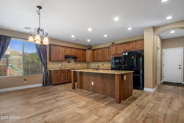 2614 E Carob Dr, Gilbert, AZ 85298 - kitchen featuring black appliances, arched walkways, under cabinet range hood, a chandelier, and light wood finished floors