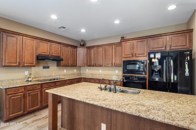 2614 E Carob Dr, Gilbert, AZ 85298 - kitchen featuring black appliances, under cabinet range hood, recessed lighting, light stone countertops, and light wood finished floors