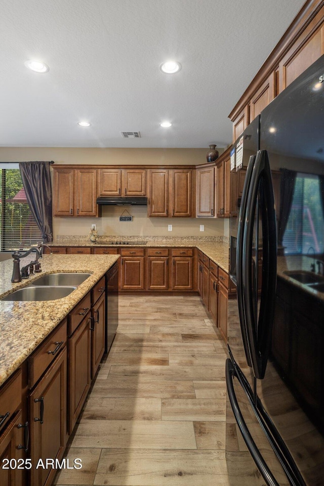 2614 E Carob Dr, Gilbert, AZ 85298 - kitchen with black appliances, light wood finished floors, recessed lighting, light stone countertops, and under cabinet range hood
