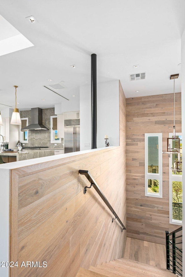 stairway featuring wood walls and light hardwood / wood-style floors