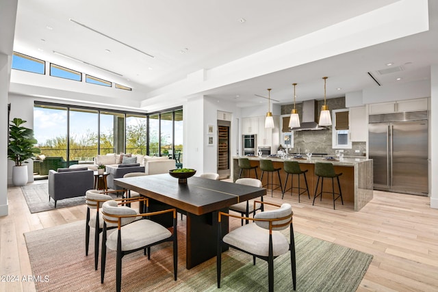 dining room featuring plenty of natural light, lofted ceiling, and light wood-type flooring