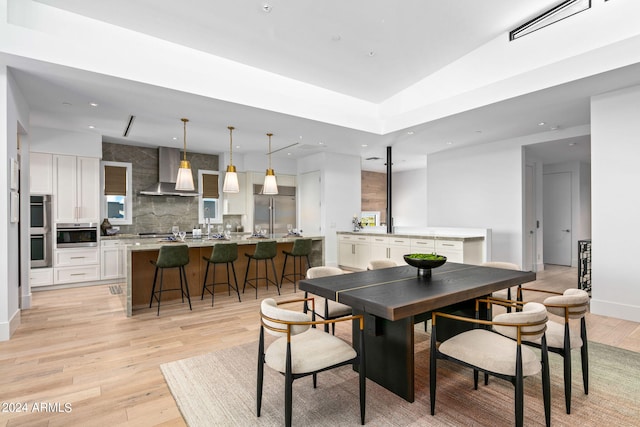 dining space featuring vaulted ceiling and light wood-type flooring