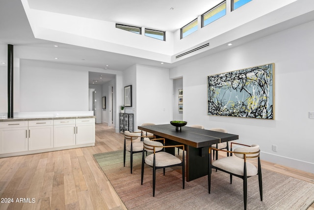 dining room featuring a high ceiling and light wood-type flooring