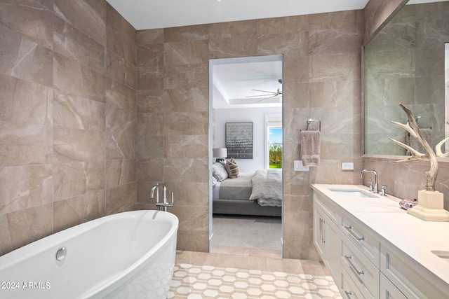 bathroom with tile flooring, double vanity, ceiling fan, tile walls, and a bathing tub