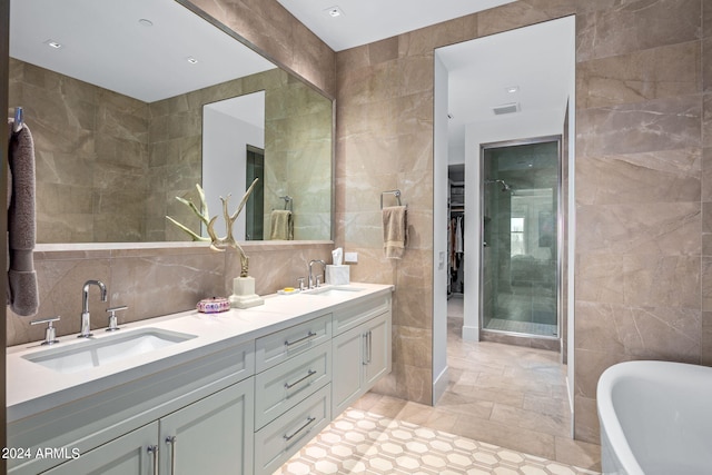 bathroom with dual sinks, tile walls, and large vanity