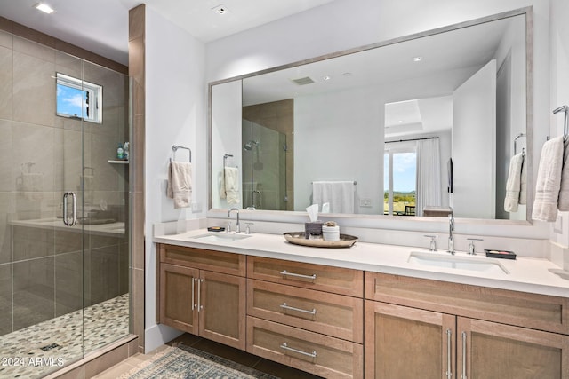 bathroom with dual vanity, tile flooring, and a shower with door