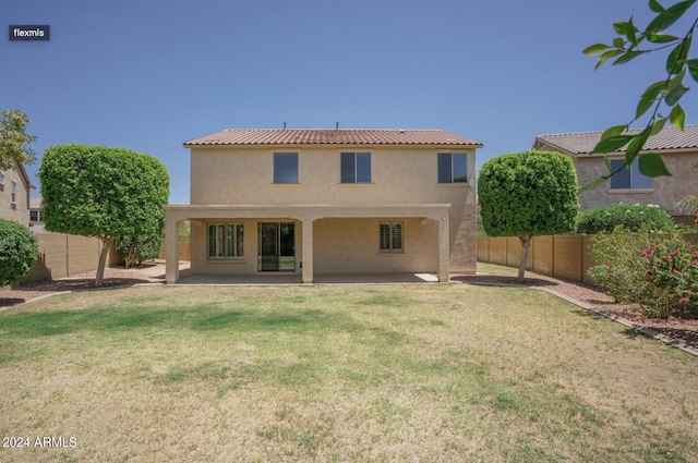 rear view of house featuring stucco siding, a patio, a lawn, and a fenced backyard