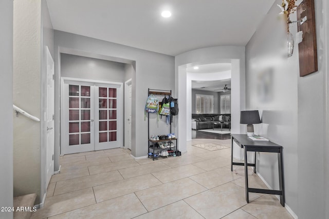 entryway with a ceiling fan, light tile patterned floors, french doors, and baseboards