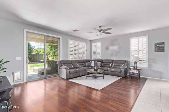 living area featuring visible vents, baseboards, a ceiling fan, and wood finished floors