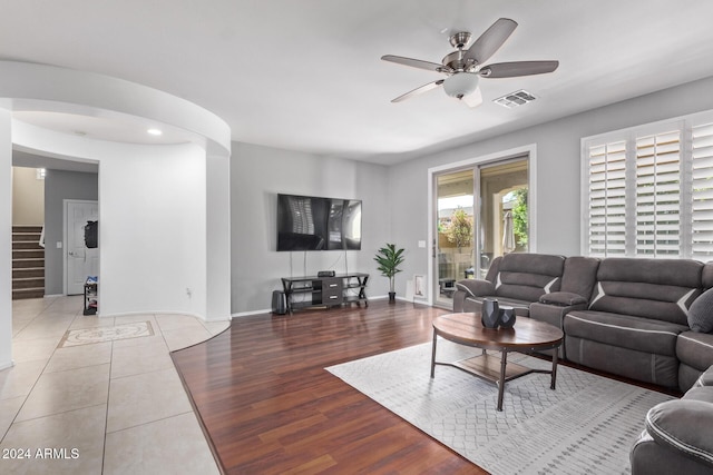 living area featuring visible vents, baseboards, stairs, wood finished floors, and a ceiling fan