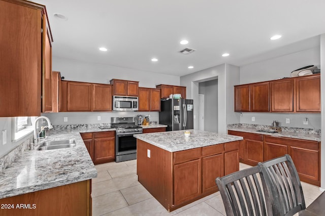 kitchen featuring a center island, light stone counters, recessed lighting, appliances with stainless steel finishes, and a sink