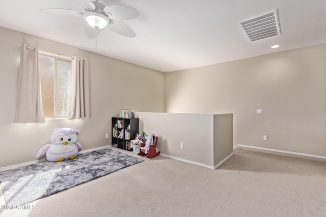 recreation room with carpet flooring, a ceiling fan, visible vents, and baseboards