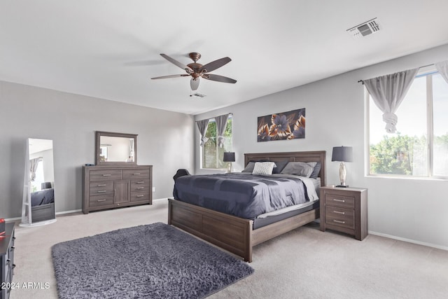 bedroom featuring visible vents, light carpet, baseboards, and a ceiling fan