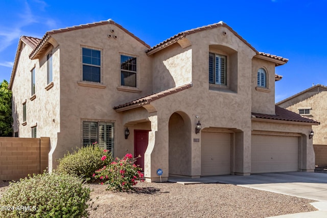 mediterranean / spanish-style house featuring stucco siding, driveway, an attached garage, and a tile roof