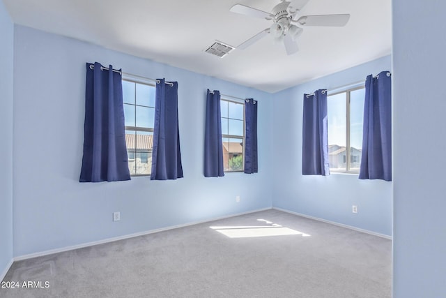 empty room featuring baseboards, visible vents, a ceiling fan, and carpet